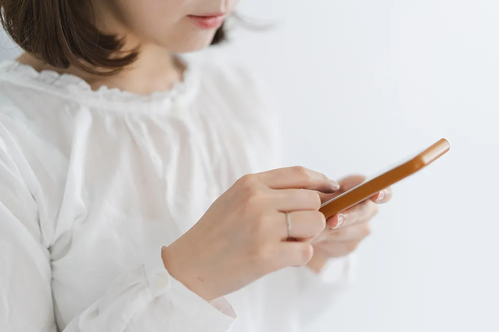 スマートフォンで受付予約をする女性